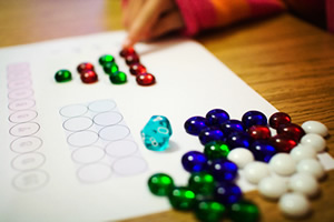 Student placing a variety of coloured beads into pattern formations